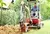 Workman using a mini digger to excavate a hole in the garden. Czech republic, Europe.