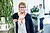Mitarbeiterin Frau Jensen mit buntem Schal steht in einer modernen Bürolandschaft mit Pflanzen im Hintergrund, während eine weitere Person im Hintergrund arbeitet. Mitarbeiterin Frau Jensen mit buntem Schal steht in einer modernen Bürolandschaft mit Pflanzen im Hintergrund, während eine weitere Person im Hintergrund arbeitet.