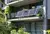 Moderne Balkonansicht mit Solarpaneelen an einem mehrstöckigen Gebäude, umgeben von grünen Pflanzen und einem klaren Himmel.