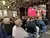 Besucher bei einer Bürgerinformationsveranstaltung in Wuppertal, mit Präsentation im Hintergrund und Publikum auf Stühlen.